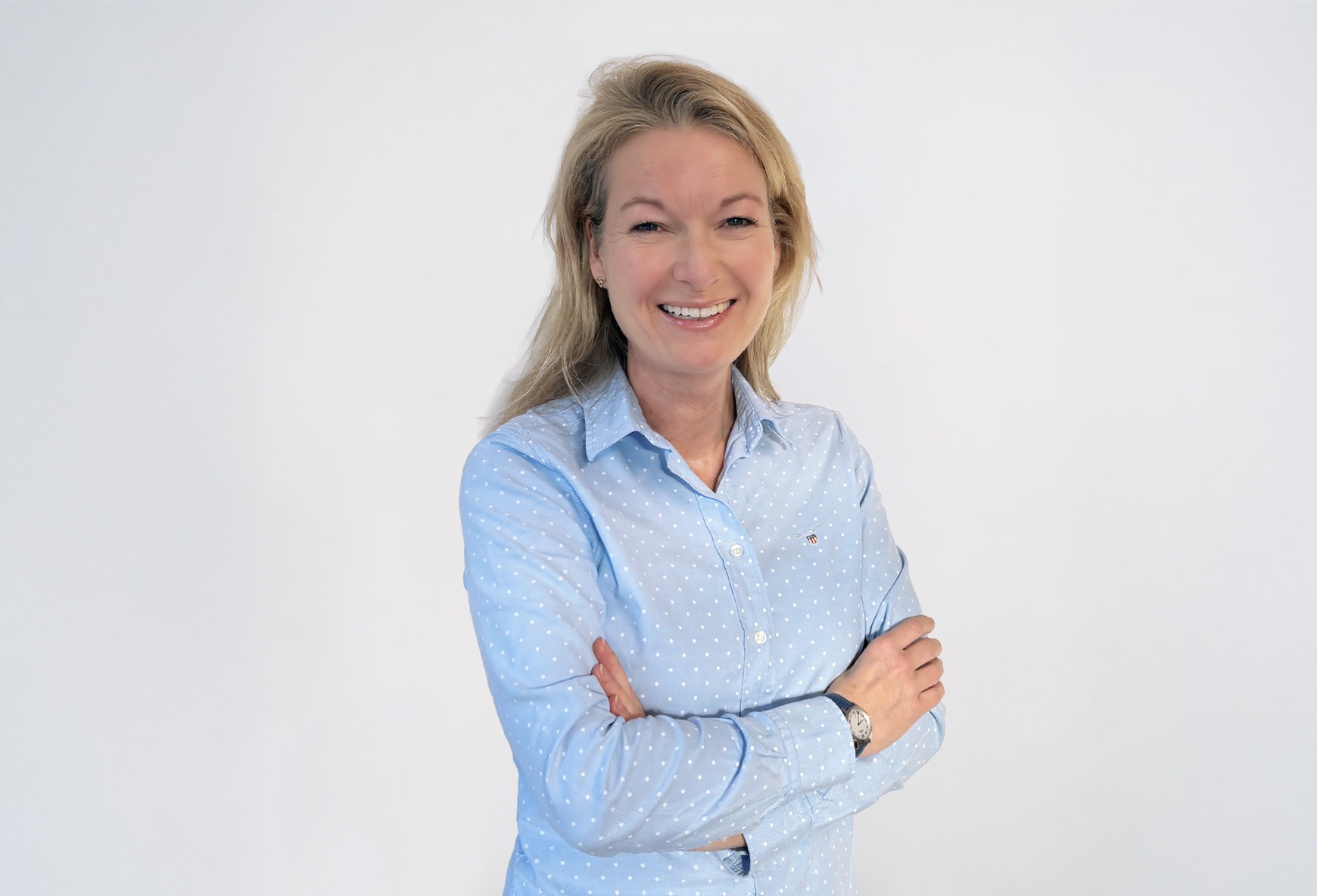 Angela Nass Porträt von Angela Nass, blaue Bluse, lächelt vor weißem Hintergrund