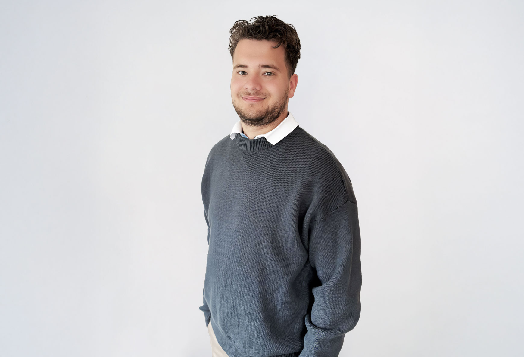 Mats_1 Ein junger Mann in grauem Pulli lächelt