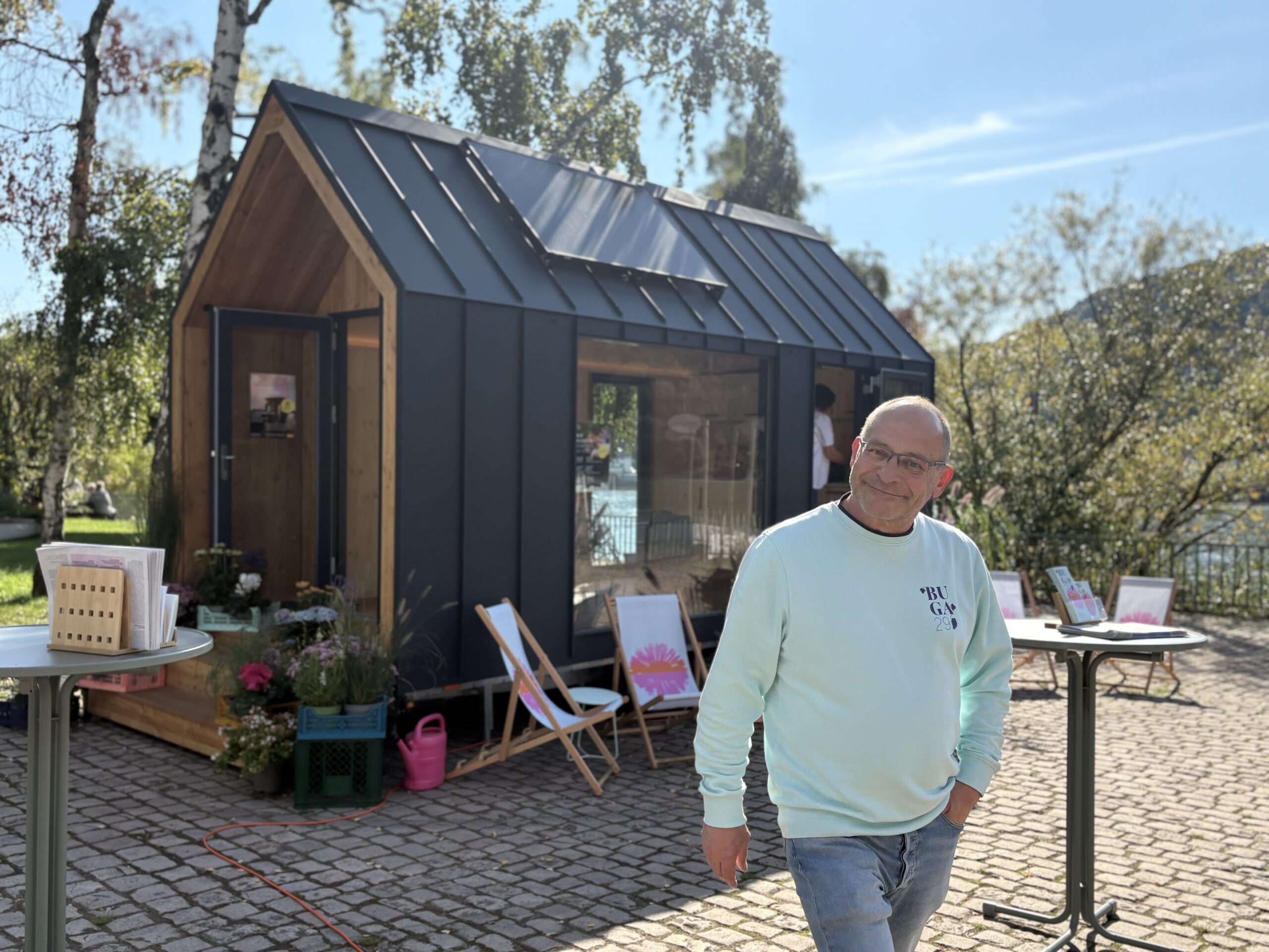 BUGA-Mitarbeiter Ralf Göppert Ein lächelnder Mann vorm BUGA-Tinyhouse