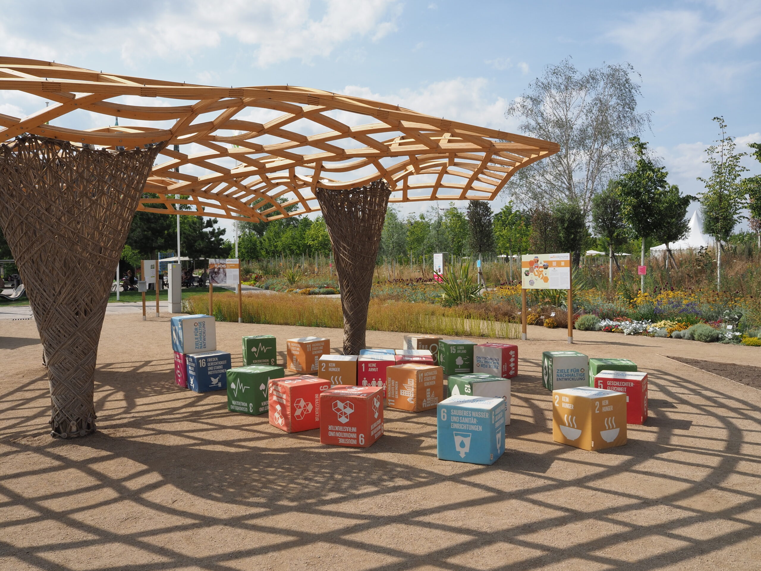 bunte Sitzwürfel unter einem Sonnenschutz aus Holz