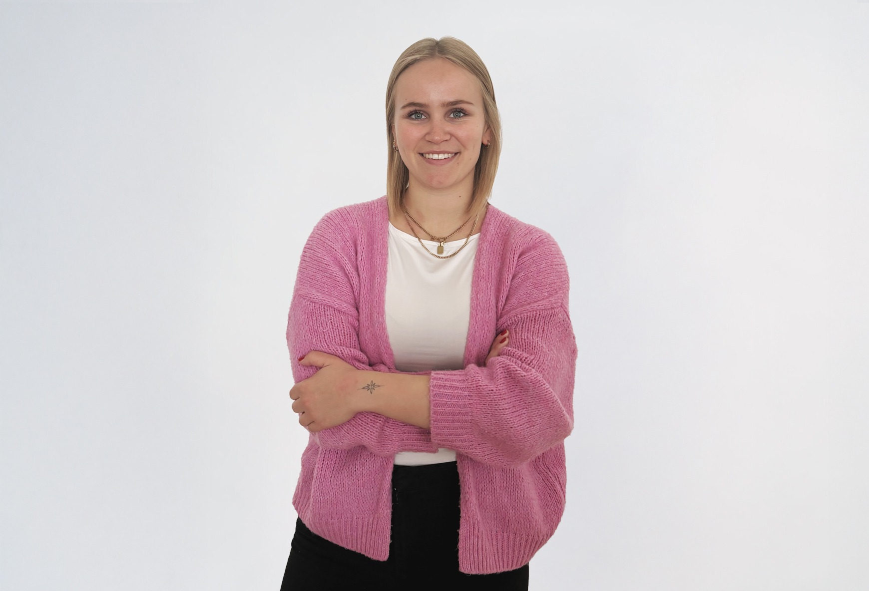 Katharina_1 Eine blonde Frau in einer rosa Strickjacke lächelt.
