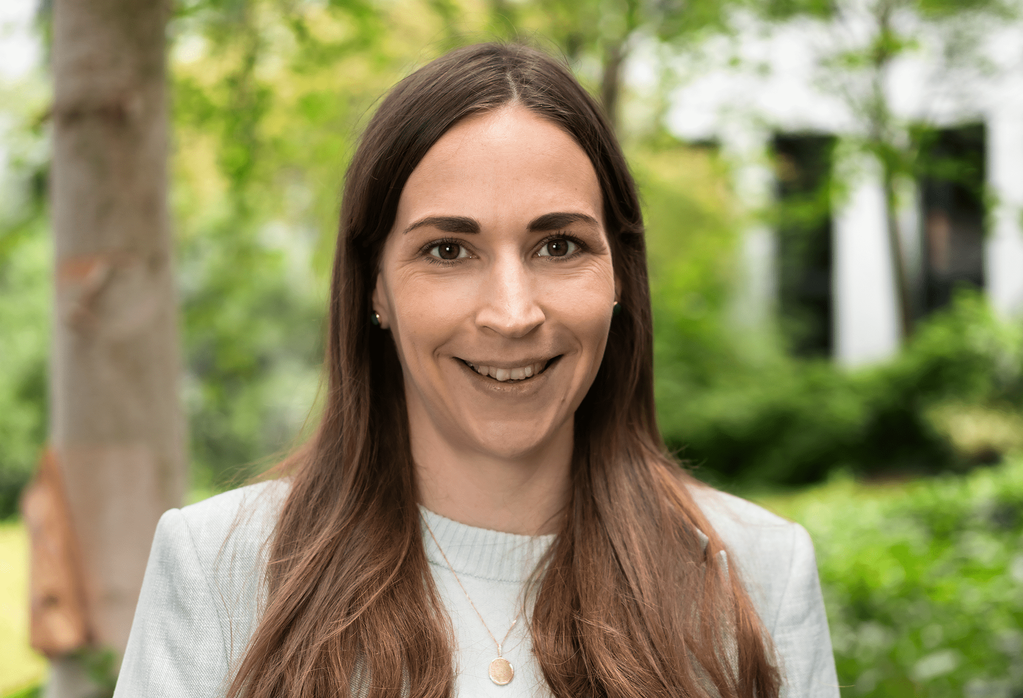 Eine braunhaarige Frau lächelt in die Kamera