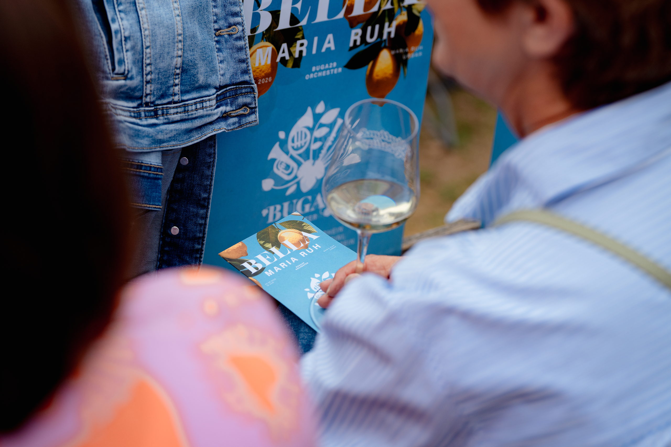 sliderimage-Bella Maria Ruh im Detail: Programmflyer und ein Glas Wein stimmen auf den Konzertabend mit dem BUGA-Orchester ein.